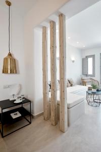 a living room with a white couch and wooden poles at Phos The Boutique in Akrotiri