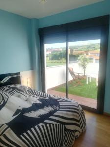 ein Schlafzimmer mit einem Bett und einem großen Glasfenster in der Unterkunft Villa Dalia in Suances + 34 Fotos