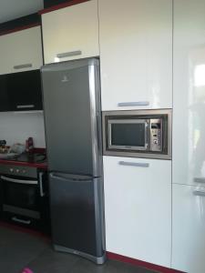 einen Kühlschrank in einer Küche mit einer Mikrowelle in der Unterkunft Villa Dalia in Suances