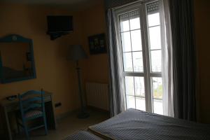 a bedroom with a bed and a large window at Hotel Pineda Playa in Noja