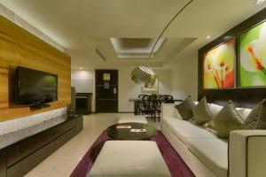 a living room with a couch and a tv at Davanam Sarovar Portico Suites in Bangalore