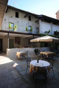 a patio with tables and umbrellas in front of a building at Hotel Sole in Sesto Calende