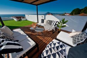 una terraza con 2 camas y una mesa en el balcón en Casa da Légua, en Moledo