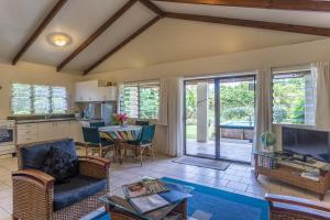 - un salon avec un canapé et une table dans l'établissement Mango Cottage, à Rarotonga