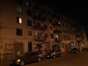 two cars parked in front of a building at night at apartament shushana in Batumi