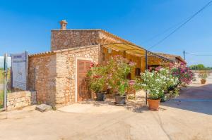 a stone building with potted plants in front of it at Sa Caseta De Ses Vaques.Son Covas in Campos