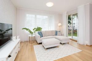 een witte woonkamer met een bank en een tv bij Tallinn City Center, brand new apartment + free parking in Tallinn