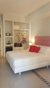 a bedroom with a large white bed with red pillows at Sorrento ResArt Suite in Sorrento