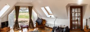 a living room with a couch and a window at The Boathouse in Stonehaven