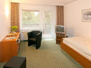 ein Hotelzimmer mit einem Bett und einem TV in der Unterkunft Hotel Zum Goldenen Hirsch in Bad Bevensen