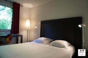アンネヴィルにあるEnzo Hôtels Premier Prix - Logis Amnévilleのベッドルーム1室(大きな白いベッド1台、枕2つ付)