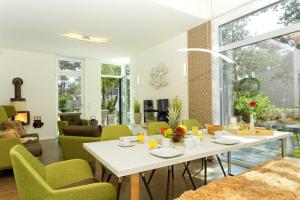 a living room with a white table and green chairs at Straße der Freundschaft 30c in Ostseebad Karlshagen