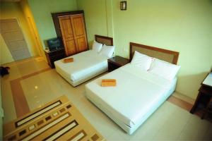 a hotel room with two beds and a television at Arwana Inn Tok Bali in Pasir Puteh +66 photos