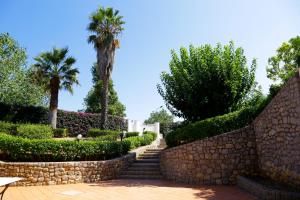 a stone wall and stairs in a park with palm trees at Il Giardino di Venere in Mondello