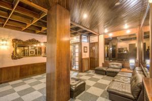 a living room with leather couches and a mirror at Hotel Residence Magnolia in Rome