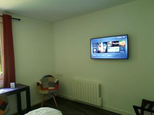 
a room with a television and a wall mounted wall mounted wall mounted wall mounted at Logis Hôtel Orion in Amnéville
