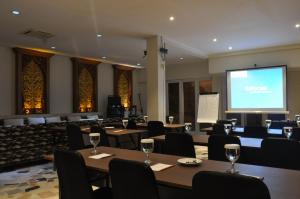 ein Konferenzraum mit Tischen und Stühlen und einer Leinwand in der Unterkunft Grand Mega Resort & Spa in Cepu + 37 Fotos