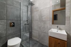 a bathroom with a shower and a toilet and a sink at Aegean Treasure Pefkos in Pefki