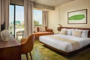 pokój hotelowy z łóżkiem i kanapą w obiekcie Penh House Hotel w mieście Phnom Penh