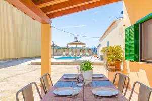 a wooden table with chairs on a patio at Sa Caseta De Ses Vaques. Son Covas (Sa Vaqueria 2) in Campos