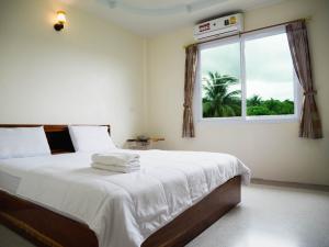 a bedroom with a large bed with a window at Khong Chiam 2 Hotel in Khong Chiam