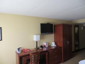 a room with a desk and a tv on a wall at Canad Inns Destination Center Grand Forks in Grand Forks