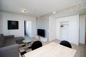 a living room with a couch and a table and a tv at Pro Apartments 1 in Vaasa