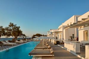 einen Pool mit Liegestühlen und ein Resort in der Unterkunft Costa Grand Resort & Spa in Kamari