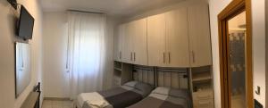 Habitación pequeña con 2 camas y TV. en Villa Grazia, en Rímini