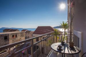 a balcony with a table and a view of the ocean at Apartments Frenkie in Komiža