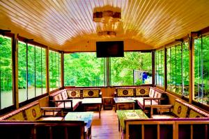 a restaurant with tables and chairs and windows at Isikli Kale Hotel in Çaykara