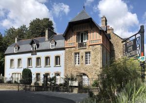 un grand bâtiment blanc avec un toit noir dans l'établissement Val Rive - Rose Cottage, à Dinan