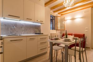 een keuken met een tafel met stoelen en een wastafel bij BRAGORA 3524 BETWEEN SAN MARCO AND BIENNALE in Venetië