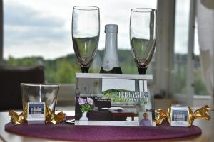 a table with two glasses and a bottle of wine at Freiwasser Appartment in Glücksburg