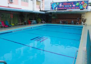 a large blue swimming pool next to a building at Angsoka Hotel in Teluk Intan
