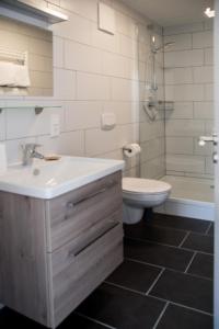 ein Bad mit einem Waschbecken, einem WC und einer Dusche in der Unterkunft Moserhof-Apartments in Igersheim