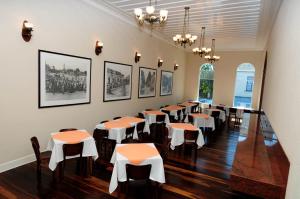 une salle à manger avec des tables, des chaises et des photos sur le mur dans l'établissement Casarão Hotel, à Brotas