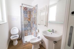 a bathroom with a toilet, sink, and shower at Liberty Suites in Palermo