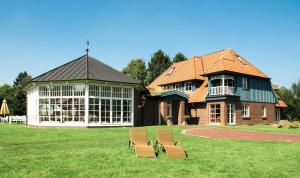 a building with two benches in front of it at Landhaus Töpferhof bei Travemünde in Travemünde