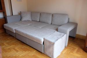 ein graues Sofa mit einer Ottomane im Wohnzimmer in der Unterkunft Borgo a Lago in Sulzano