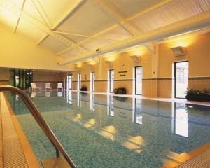 a pool in a building with a swimming pool at De Vere Wokefield Estate in Reading