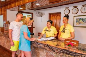 a group of people standing around a counter at La Digue Island Lodge in La Digue