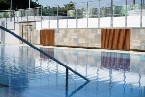 an empty swimming pool with a hand rail in the water at Studio One Accommodation Suites in Bucharest