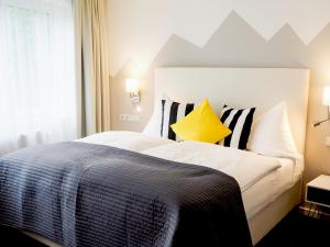 a bedroom with a large bed with black and white pillows at Hotel Saalbacher Hof in Saalbach-Hinterglemm