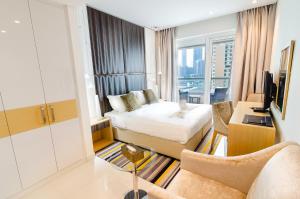 a hotel room with a bed and a living room at OSKENA Vacation Homes - Waterfront Downtown in Dubai