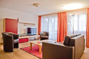 een woonkamer met een bank en stoelen en een televisie bij Apartment Stotzhalten 2.5 - GriwaRent AG in Grindelwald