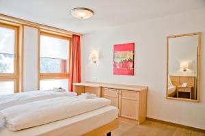 1 dormitorio con cama y espejo en Apartment Stotzhalten 2.5 - GriwaRent AG, en Grindelwald