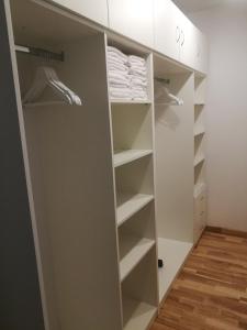 a walk in closet with white cabinets and white towels at Centro apartamentai in Druskininkai