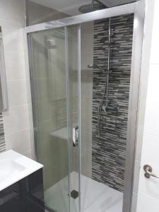La salle de bains est pourvue d'une douche avec une porte en verre. dans l'établissement VERDEMAR 39 MENYBER, à Nerja