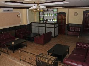 a restaurant with couches and tables and a bar at Marton Skazka Hotel in Rostov on Don